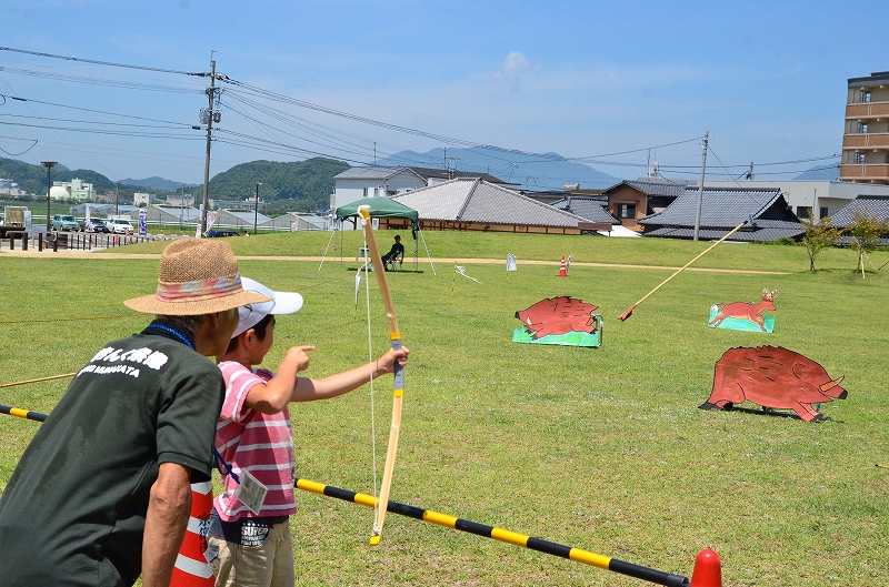 動物の形の的に向かって弓をかまえる子ども（これまでの弓矢体験のようす）